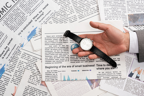 top view of businessman holding wristwatch in hand