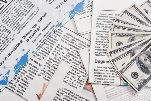 top view of dollar banknotes on newspapers