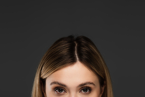 cropped view of young woman with natural makeup looking at camera isolated on grey