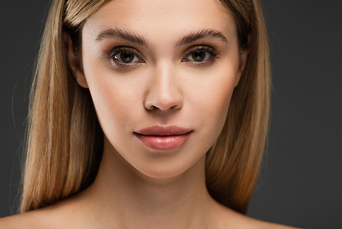 portrait of young woman with natural makeup and perfect skin isolated on grey