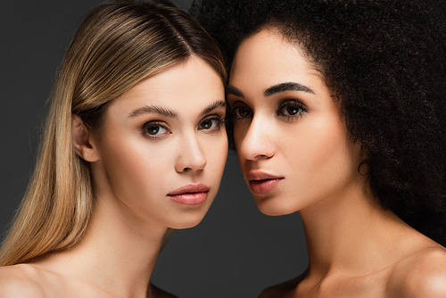 pretty interracial women with clean skin and natural makeup isolated on grey