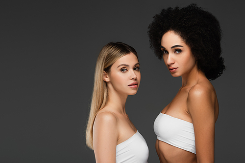 young multiethnic women in white tops and natural makeup  isolated on grey