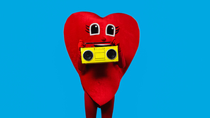 person in red heart costume holding retro boombox isolated on blue