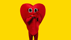 person in red heart costume touching cartoon eyes while imitating crying isolated on yellow