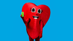 person in positive heart costume holding smartphone with green screen isolated on blue
