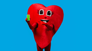person in positive heart costume pointing at smartphone with green screen isolated on blue