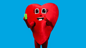 person in positive heart costume holding smartphone with green screen and showing like isolated on blue