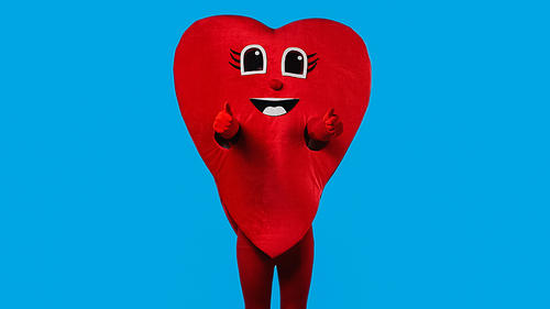person in positive heart costume showing thumbs up isolated on blue