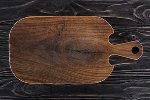 top view of wooden cutting board on black table
