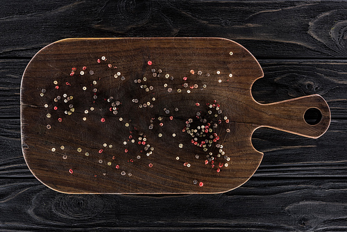 top view of wooden cutting board with spices on table