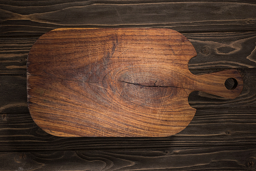 top view of wooden cutting board on brown table