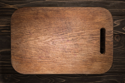top view of wooden cutting board on black table