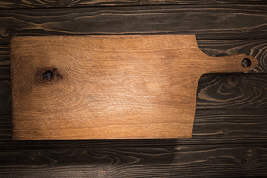 top view of wooden cutting board on brown table