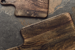 top view of brown wooden cutting boards on weathered grey background