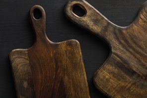 Top view of brown wooden cutting boards on dark surface