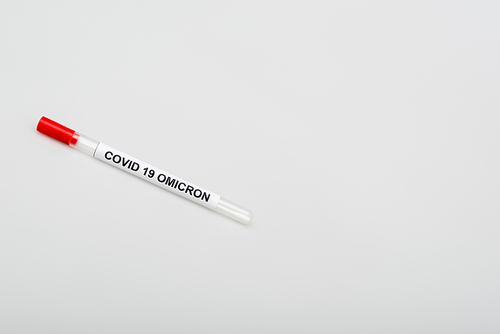 top view of covid-19 omicron test tube on grey background with copy space