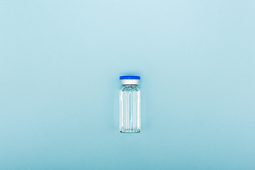 top view of vaccine bottle on blue background, omicron variant concept