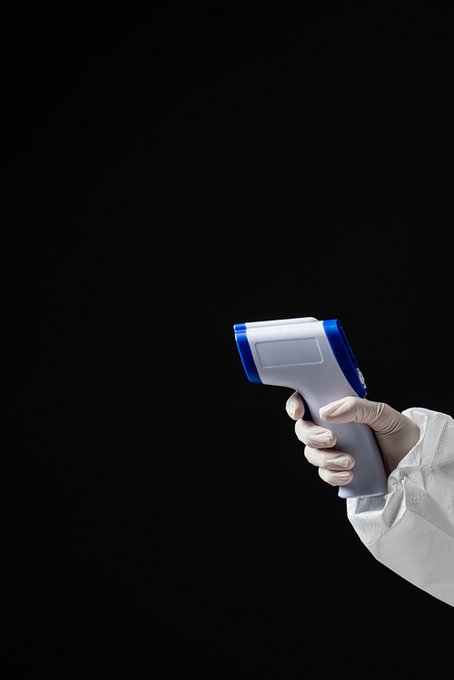 cropped view of doctor in latex glove holding pyrometer isolated on black with copy space