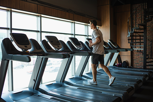 full length view of sportsman running on treadmill in sports center
