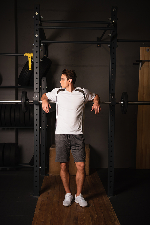 full length view of man in sportswear standing near weightlifting exercising machine in gym