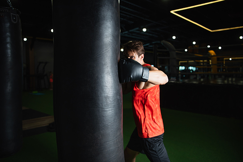 boxer working out with punching bag in sports center