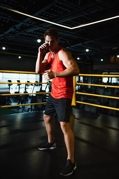 full length view of sportsman working out in boxing ring in gym