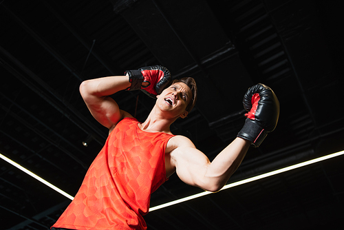 low angle view of boxer screaming while training in sports center