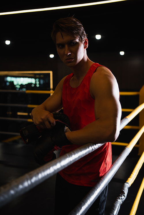 sportive man looking away while standing in boxing ring