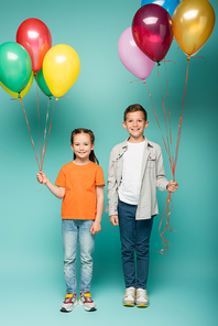 happy children holding colorful balloons on blue