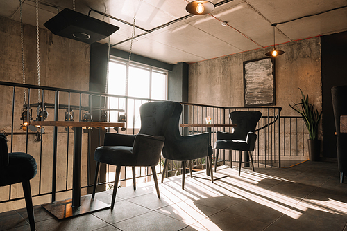 balcony with tables and chairs in modern loft coffee house in sunlight
