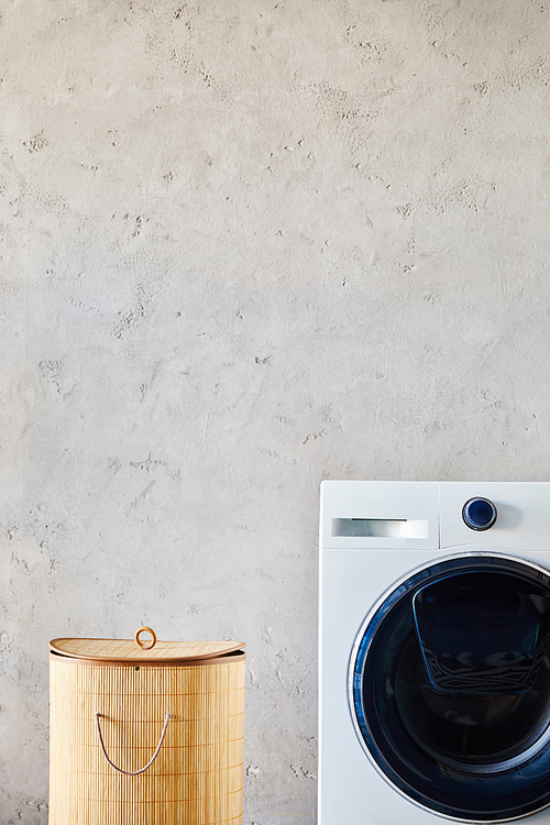 laundry basket near white washing machine in modern bathroom