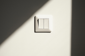 sunshine on white switch on wall in apartment