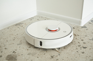 modern automatic vacuum cleaner washing floor tiles in apartment