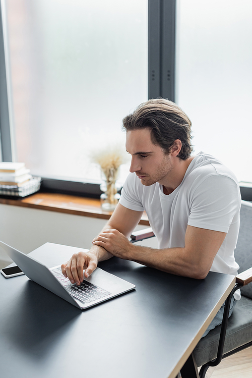 concentrated freelancer looking at laptop while working from home