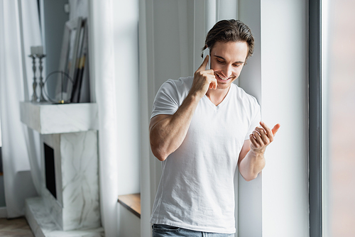 cheerful man talking on cellphone at home