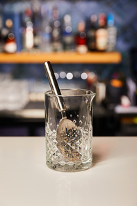 silver spoon in empty glass on bar counter