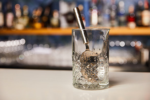silver spoon in empty glass on bar stand