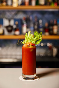 bloody mary cocktail with celery and tasty shrimp in glass