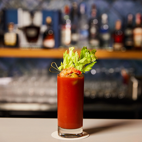 bloody mary cocktail with celery and shrimp in glass