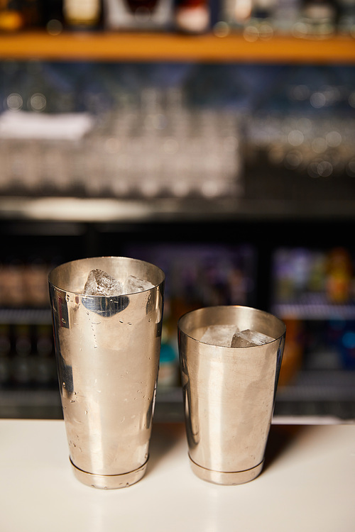 shakers with frozen ice cubes on bar counter
