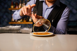 cropped view of barman holding margarita glass near saucer with brown sugar
