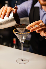 cropped view of man holding shaker near sieve and margarita glass