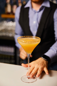 cropped view of barman holding margarita glass with cold cocktail