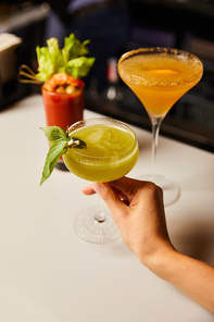 cropped view of woman holding margarita glass with fresh cocktail