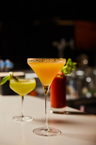 selective focus of mixed cold cocktails in glasses on bar counter