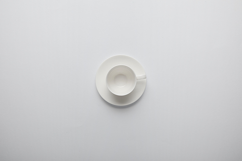 Top view of empty cup and saucer on grey