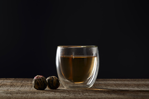 transparent glass with blooming tea isolated on black with copy space
