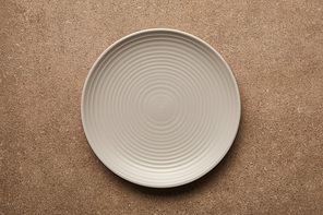 top view of empty white plate on textured surface