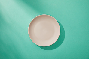 Top view of empty plate on turquoise background