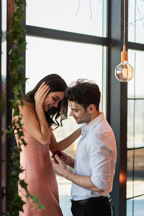 happy man making proposal to girlfriend in slip dress